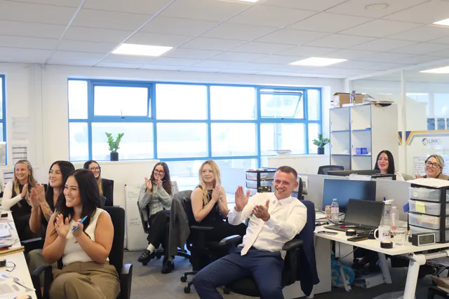 Delegates laughing and applauding during a training session